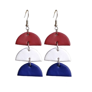 Detail of red white and blue clay earrings with three tiered geometric fan shapes