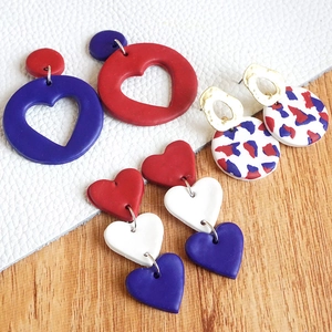 Macro shot of red white and blue polymer clay heart earrings with vibrant pattern detail