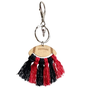 Handmade American football wooden keychain with red and black cotton tassels on white background