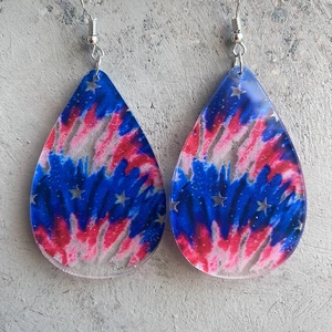 Close-up of rainbow tie-dye resin teardrop earrings with silver star sequins and fish hooks