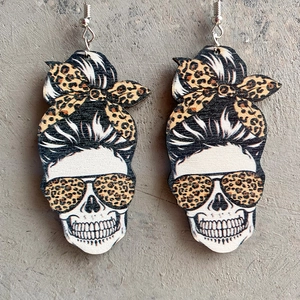 Detail of wooden skull earrings with leopard print bow and American tie-dye baseball motif