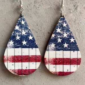 Detail of teardrop wooden earrings featuring a distressed American flag star and stripe pattern
