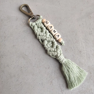 Detail of handmade macrame keychain with sage green fringe and MAMA wooden beads