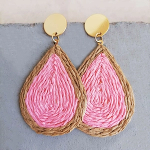 Pink bohemian woven raffia teardrop earrings with golden hooks on stone background