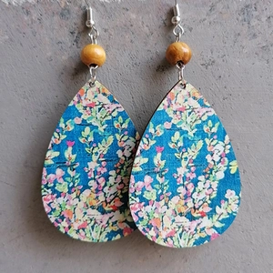 Bohemian teardrop earrings with blue floral print and wooden beads on grey background