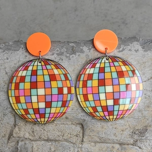 Retro disco ball style colorful checkered resin drop earrings on a stone background
