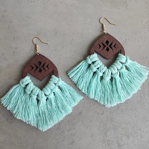 Detailed view of bohemian wood diamond earrings with mint green fringe and laser cutouts