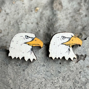 Rustic wooden eagle stud earrings with detailed bald eagle print on stone surface