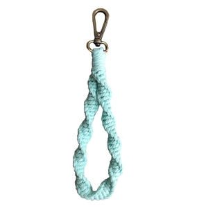 Handmade bohemian mint green woven keychain with a vintage bronze spring clasp on white background
