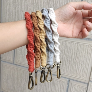 Five assorted bohemian hand-woven cotton wrist straps with vintage metallic hooks on arm