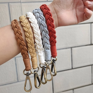 Detail of five handmade bohemian woven keychains in earthy colors with lobster clasps