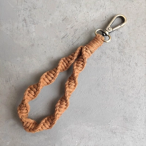 Detail of caramel hand-woven macrame wristlet strap with vintage metal lobster clasp