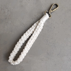 Détail d'un bracelet macramé en coton avec fermoir mousqueton bronze de style Boho