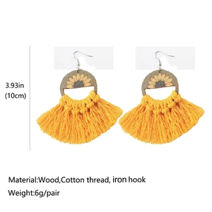 Detail view of bohemian sunflower earrings showing 10cm size and wooden texture