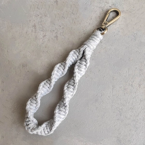 Close-up of handmade bohemian spiral macrame keychain with bronze lobster clasp