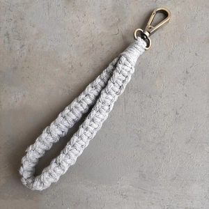 Détail d'un bracelet macramé gris fait main avec un fermoir mousqueton en bronze