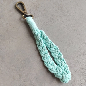 Detail of mint green hand-woven cotton keychain with antique brass carabiner hook