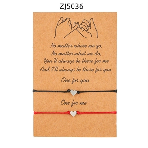 Dettaglio dei bracciali intrecciati con cuore su biglietto regalo per coppie o amici