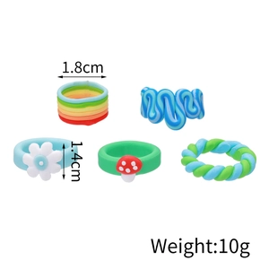 Detail showing dimensions of five colorful handmade clay rings with floral and mushroom motifs