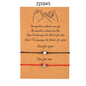 Dettaglio di braccialetti di coppia con stella intrecciata su confezione in carta kraft