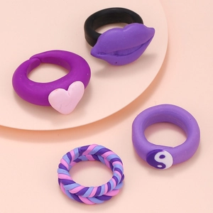 Close-up of Y2K style polymer clay rings featuring heart, lips, and yin-yang designs