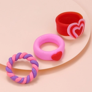 Close-up of cute clay rings set featuring heart patterns and colorful twisted rope designs