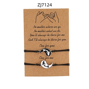 Dettaglio di braccialetti intrecciati neri regolabili con ciondoli yin yang neri e bianchi