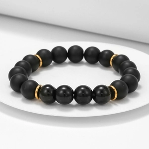 Detaillierte Makroansicht des schwarzen Achat-Perlenarmbands mit goldenen Metallelementen