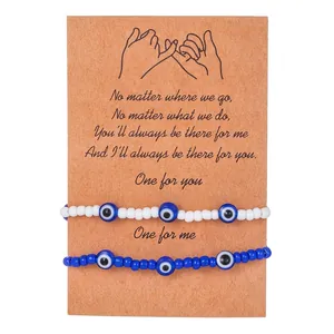 Detail view of two Evil Eye beaded bracelets on a Pinky Swear kraft card packaging