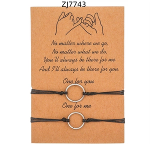 Dettaglio della carta Pinky Promise con due braccialetti dell'amicizia in corda nera intrecciata