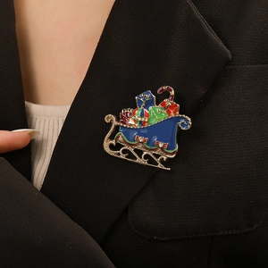 Detailed view of an enamel Christmas sleigh brooch with rhinestones on a black suit lapel