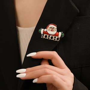 Detailed view of an enamel Santa Claus brooch with HOHOHO sign on a black suit lapel