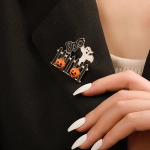 Detail of Halloween enamel brooch with pumpkins and ghost on a black suit lapel