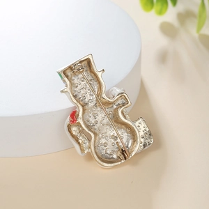 Macro view of snowman brooch back featuring golden alloy metal and safety pin clasp
