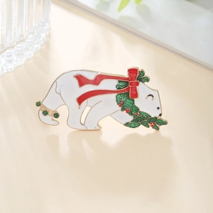 Detail of Christmas polar bear brooch with red bow and green rhinestone accents