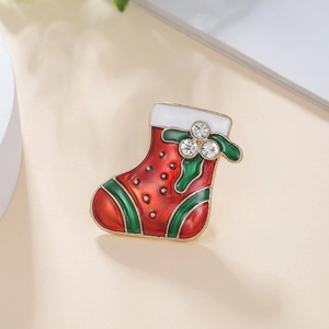 Detailed view of a Christmas stocking brooch with red enamel and sparkling rhinestones