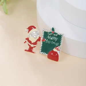 Macro detail of enamel Santa Claus brooch with Merry Christmas sign on white podium