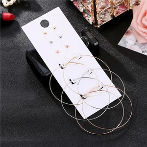 Detailed set of gold, silver, and rose gold hoop earrings and studs on a display card