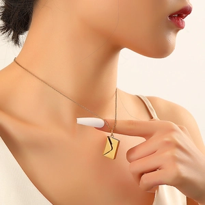 Elegant gold envelope pendant necklace for women worn by a model in warm lighting