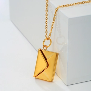 Macro detail of a gold envelope necklace with a realistic folding pendant and O-chain