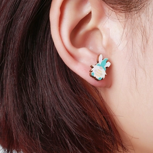 Detalle de un pendiente de madera con gnomo de Pascua usado en la oreja de una modelo