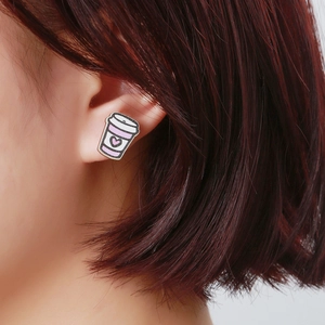 Close-up of a pink heart coffee cup earring worn on a model for a cute festive look