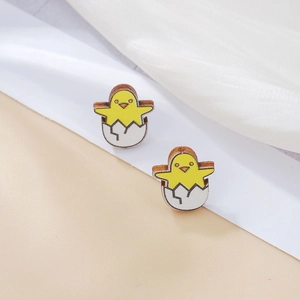 Detalle de pendientes de madera hechos a mano con diseño de pollito amarillo lindo