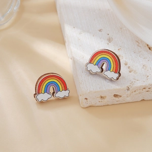 Detalle de pendientes de arcoíris de madera con rayas de colores y nubes blancas