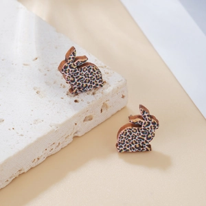 Primer plano de pendientes de madera con forma de conejo y estampado de leopardo de colores