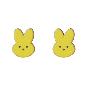 Detalle de pendientes de botón con forma de conejo amarillo hechos de madera grabada