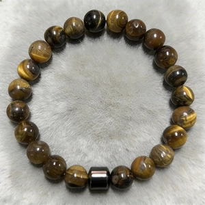 Macro shot of 8mm tiger eye stone beads bracelet with black cylindrical metal charm