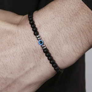 Herenarmband met boze oog, matzwarte kralen en zilveren accenten gedragen om de pols