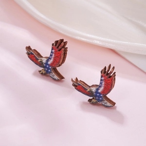 Macro shot of eagle-shaped wooden earrings featuring American flag stars and stripes pattern