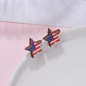 Close-up of star-shaped wooden stud earrings featuring the American flag design